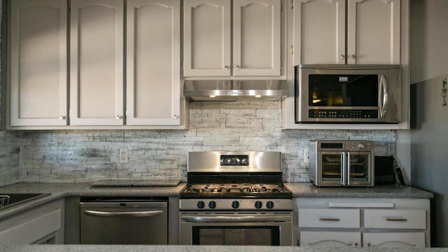 kitchen with white cabinets, stainless steel appliances, and tasteful backsplash