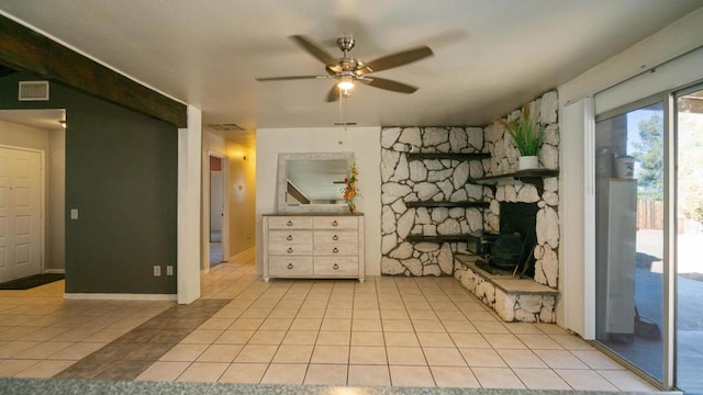 unfurnished living room with a fireplace, light tile patterned floors, and ceiling fan