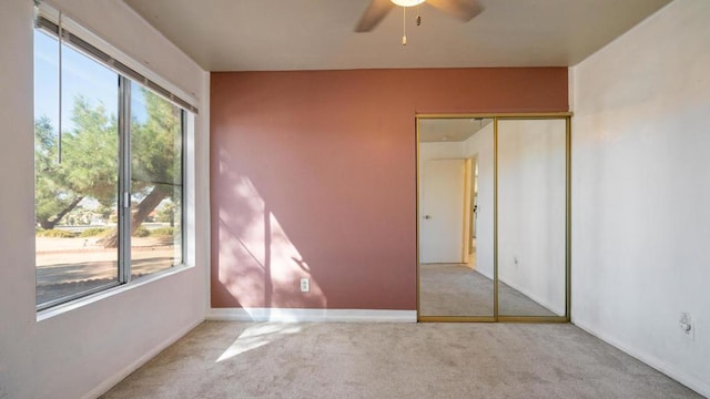 spare room featuring plenty of natural light, ceiling fan, and light carpet