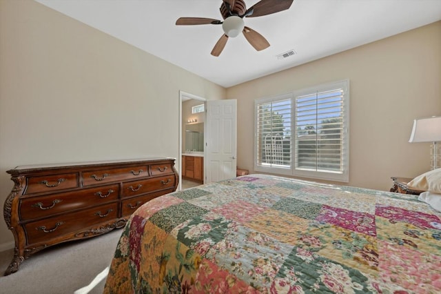 carpeted bedroom featuring ensuite bath and ceiling fan