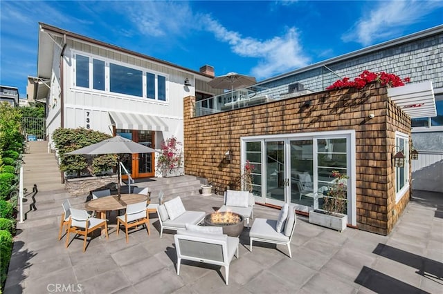 738 Cliff Dr, Laguna Beach, CA 92651 - view of patio with an outdoor fire pit, stairway, french doors, and outdoor dining area