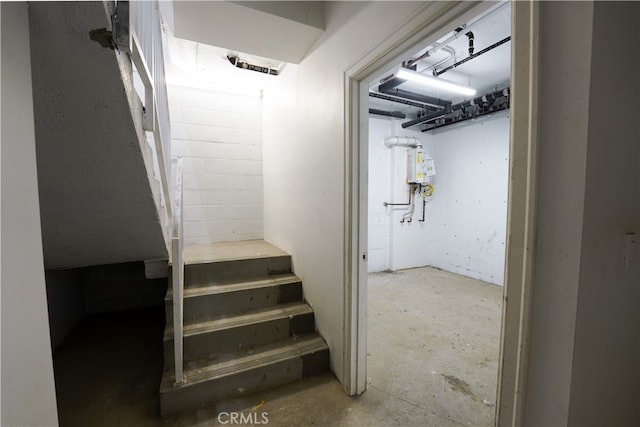 stairs featuring concrete flooring