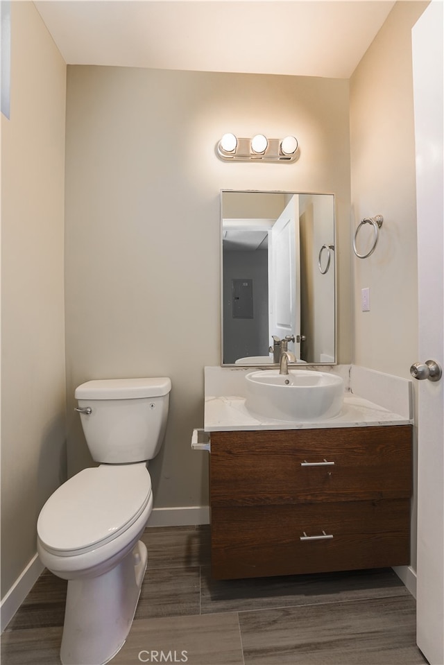 bathroom with vanity, toilet, and hardwood / wood-style flooring