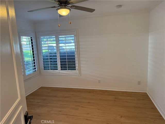 empty room with crown molding, ceiling fan, and wood-type flooring