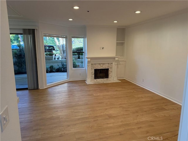 unfurnished living room featuring a premium fireplace and light wood-type flooring