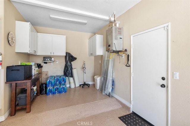 garage with baseboards and water heater