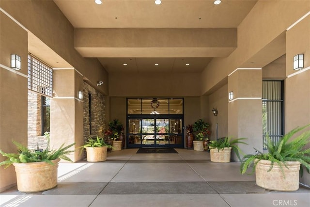 property entrance featuring stucco siding and french doors