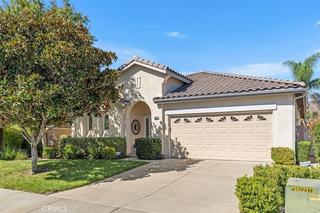 mediterranean / spanish home featuring concrete driveway, a tiled roof, an attached garage, and stucco siding