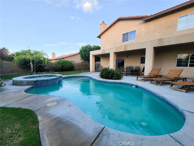 view of pool featuring a patio area and an in ground hot tub