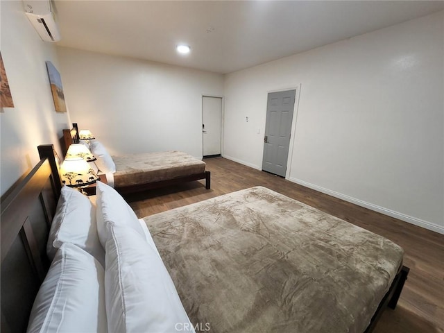 bedroom with an AC wall unit and dark hardwood / wood-style flooring