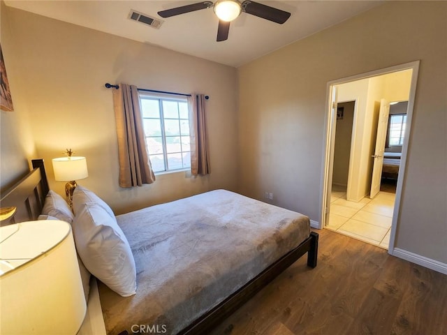 bedroom featuring multiple windows, dark wood-type flooring, and ceiling fan