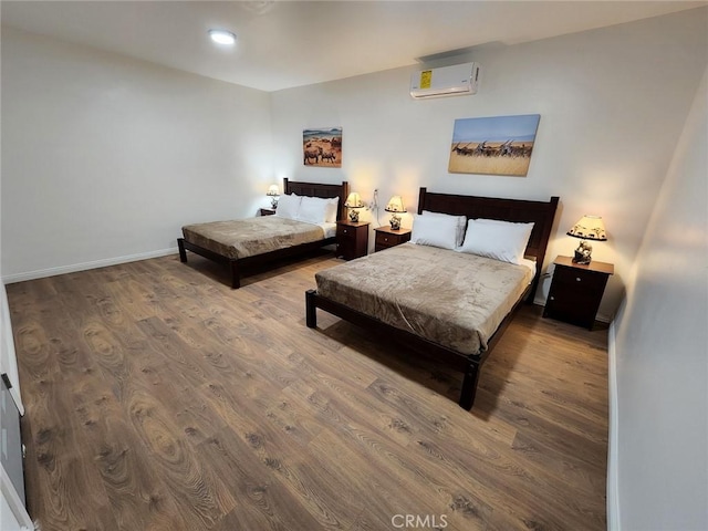 bedroom featuring wood-type flooring and a wall mounted AC