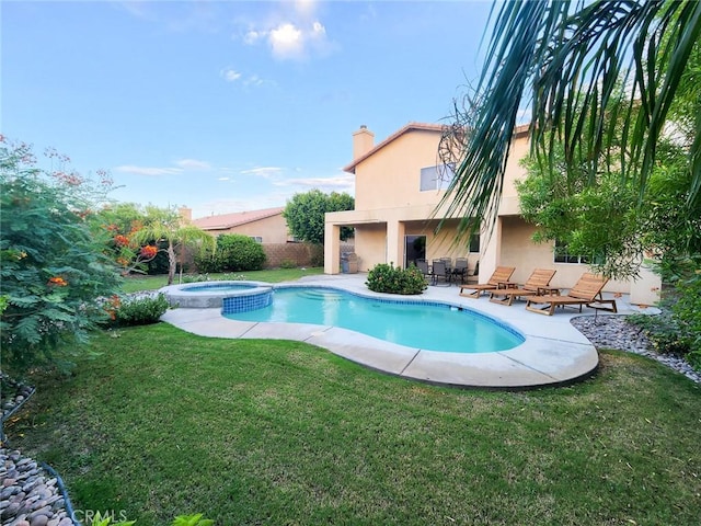 view of pool with a patio area, a yard, and an in ground hot tub