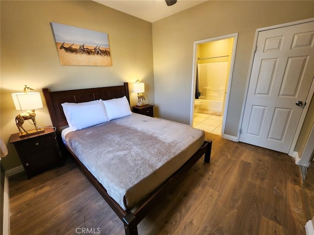 bedroom featuring ensuite bathroom and dark hardwood / wood-style floors