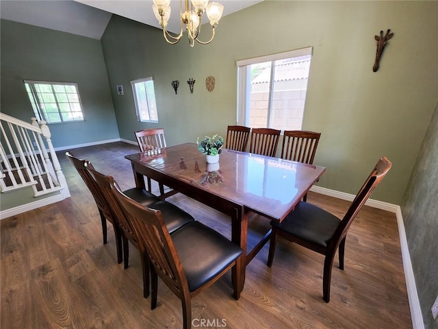 dining room featuring dark hardwood / wood-style flooring, lofted ceiling, and a chandelier