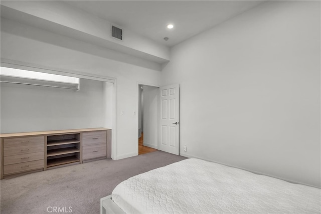 bedroom featuring light carpet and a closet