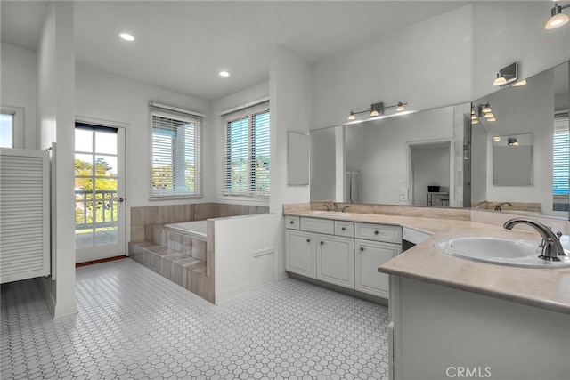 bathroom with vanity and a relaxing tiled tub