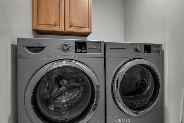 laundry area featuring cabinets and washer and clothes dryer