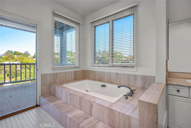 bathroom featuring tile patterned floors, tiled tub, and vanity