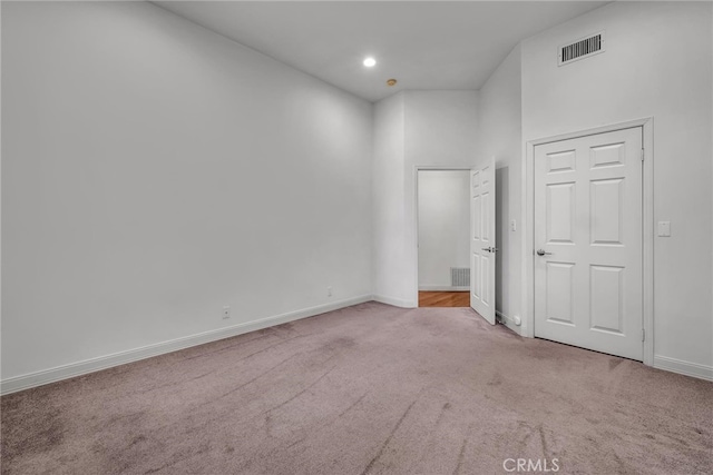 carpeted spare room with a high ceiling