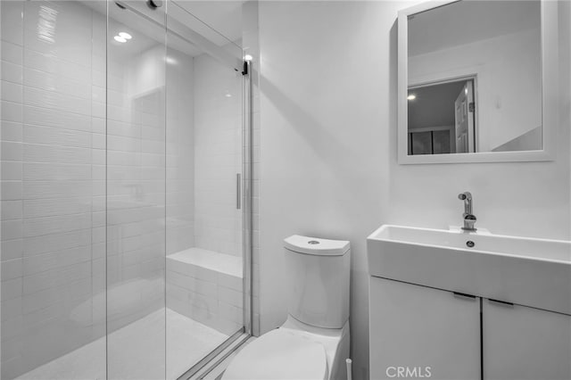 bathroom featuring an enclosed shower, vanity, and toilet