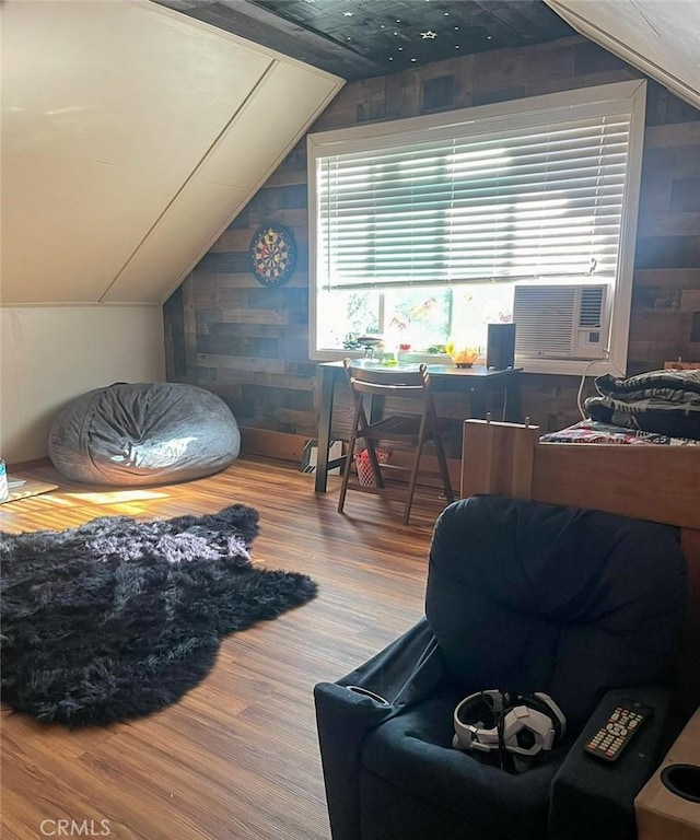 interior space featuring cooling unit, lofted ceiling, and hardwood / wood-style flooring