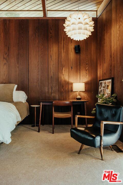 sitting room featuring wood walls, wood ceiling, and carpet floors