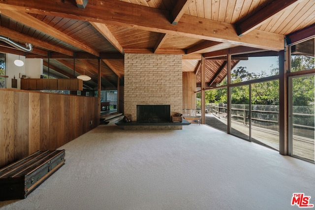 unfurnished living room featuring a fireplace, carpet floors, expansive windows, and wooden ceiling