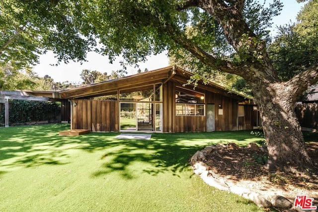 rear view of property with a yard