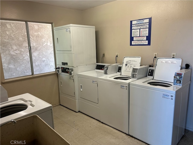 washroom featuring stacked washer / dryer, a healthy amount of sunlight, and washing machine and dryer