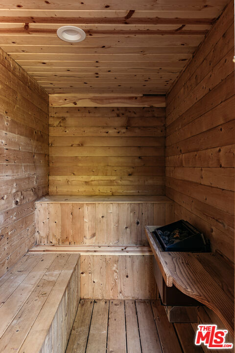 view of sauna / steam room with hardwood / wood-style flooring, wooden ceiling, and wood walls