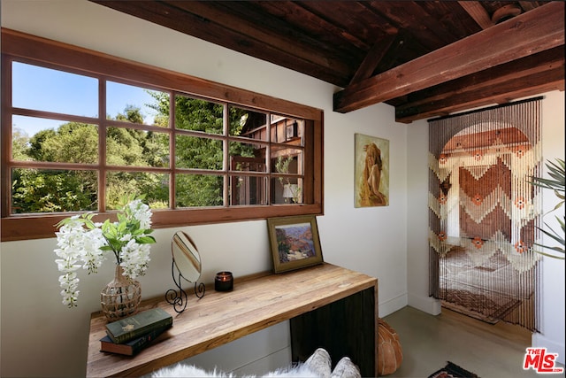 home office featuring beamed ceiling, wood ceiling, and concrete flooring