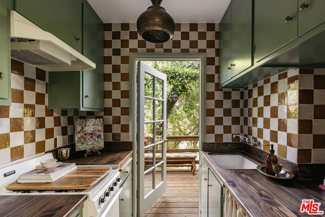 kitchen with butcher block counters, green cabinets, white range oven, sink, and light wood-type flooring