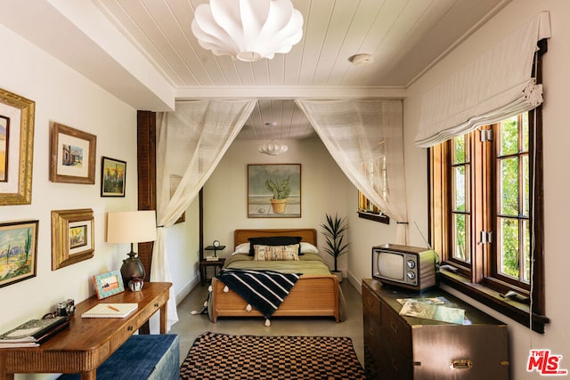 bedroom with wooden ceiling, multiple windows, and light colored carpet