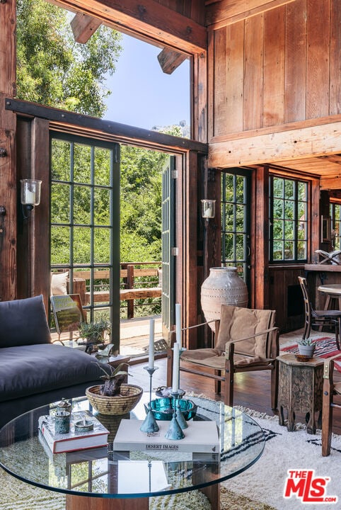 living room with wood walls and a high ceiling