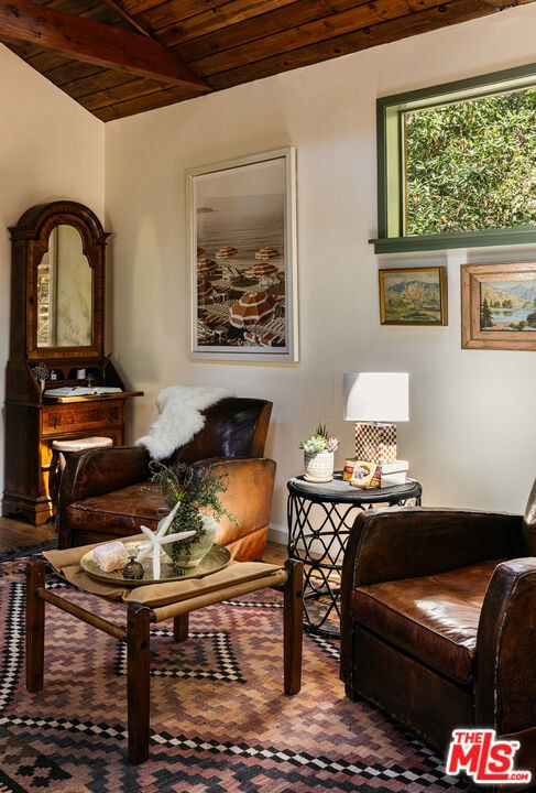 living area featuring vaulted ceiling with beams and wood ceiling