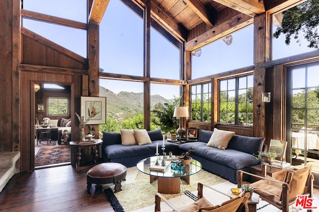 sunroom with a mountain view, wooden ceiling, and vaulted ceiling with beams