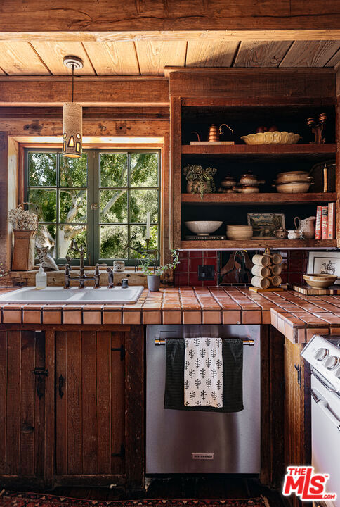 kitchen featuring tile countertops, dark brown cabinetry, and wooden ceiling