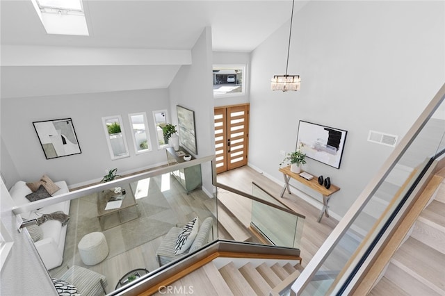 entryway featuring high vaulted ceiling, a notable chandelier, and light wood-type flooring