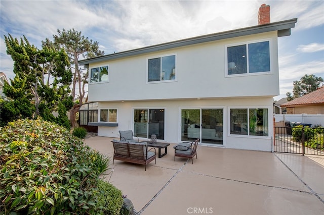 back of property featuring a patio and an outdoor hangout area