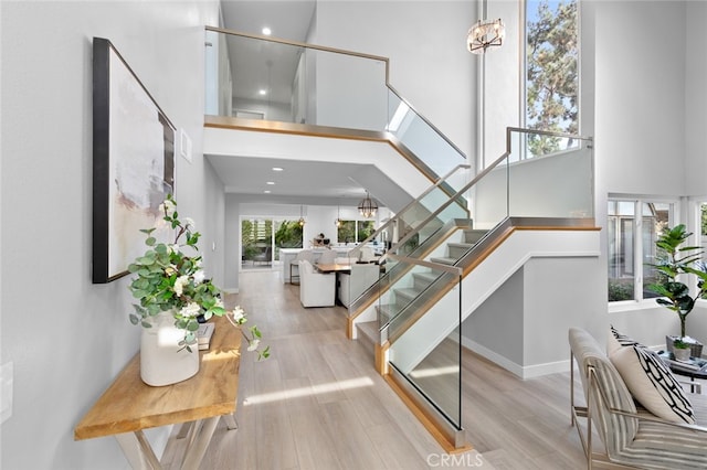 stairs featuring hardwood / wood-style floors and a high ceiling