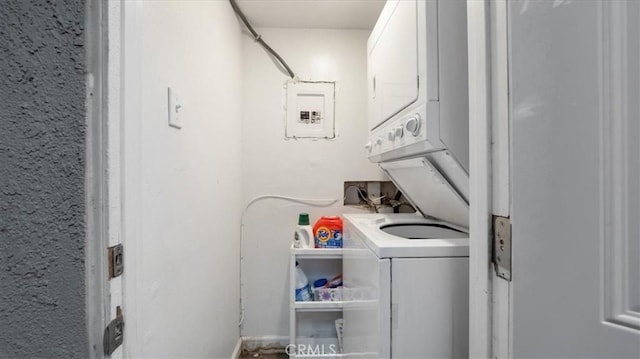 laundry room with laundry area, stacked washing maching and dryer, and electric panel
