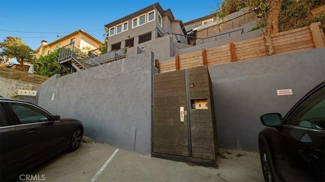 view of side of home with fence and stucco siding