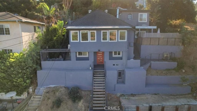 view of front of property featuring stairs and stucco siding