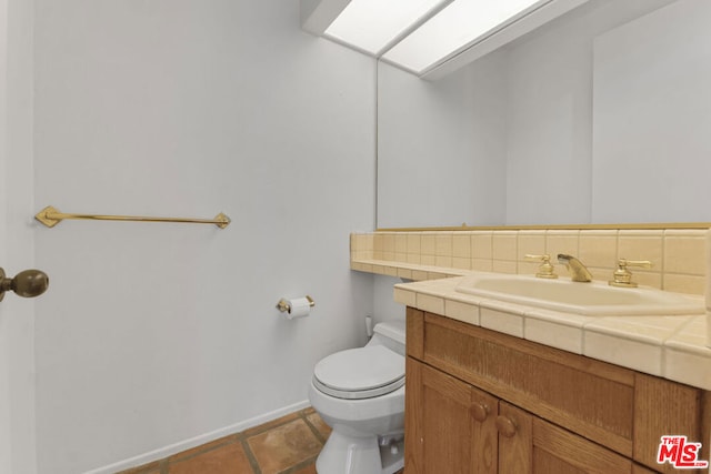 bathroom with backsplash, tile patterned floors, vanity, and toilet