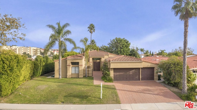 mediterranean / spanish-style house featuring a front yard and a garage