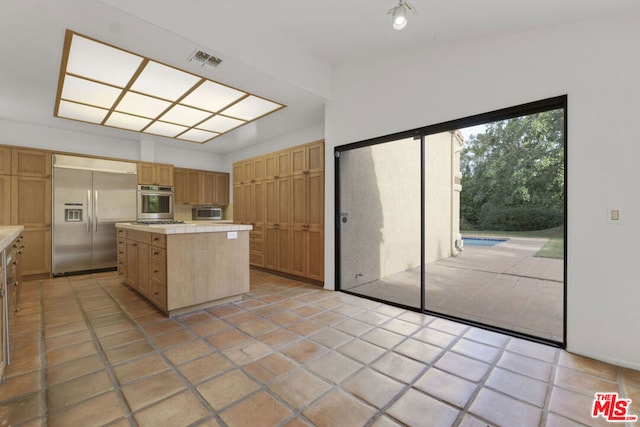 kitchen featuring a center island, light tile patterned floors, and appliances with stainless steel finishes