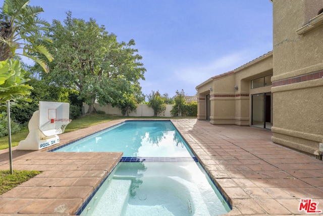 view of swimming pool featuring a patio area and an in ground hot tub