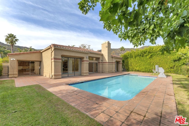 view of swimming pool featuring a patio area and a yard