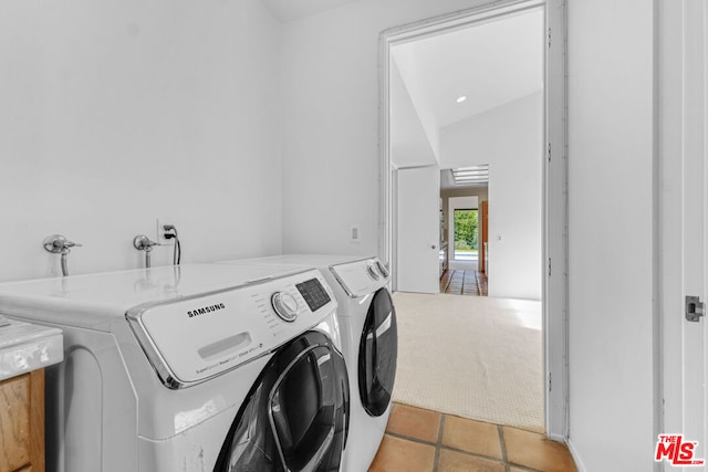 laundry area with washer and dryer and light tile patterned floors